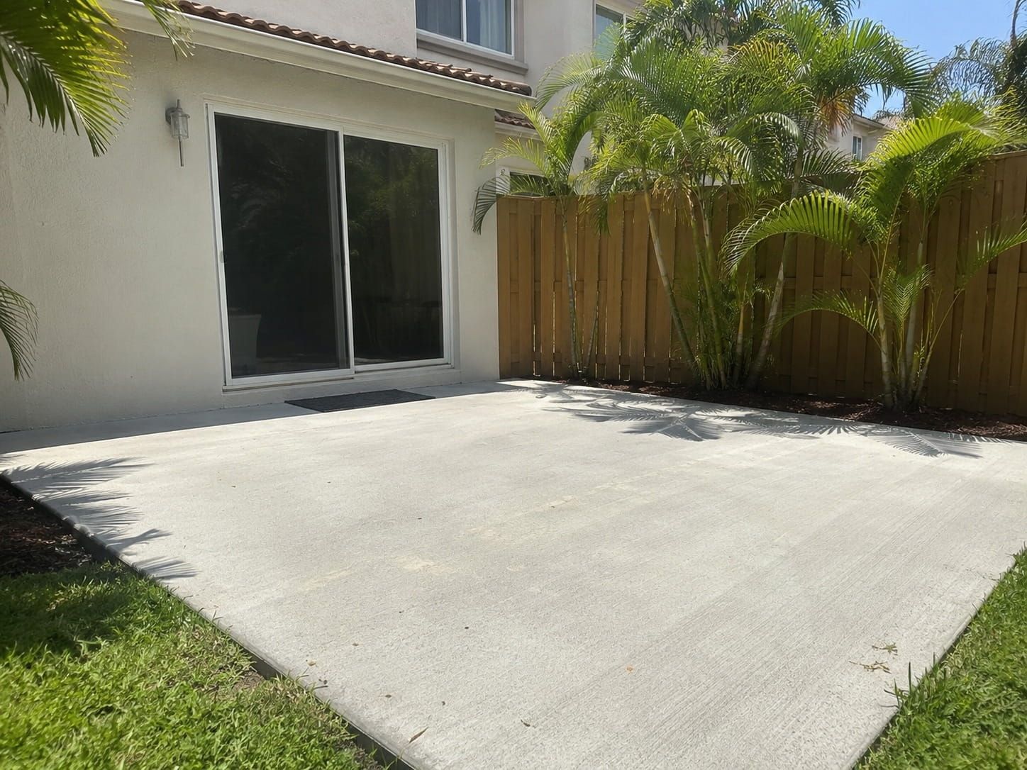 private fenced concrete patio in a Miami backyard