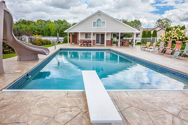 backyard swimming pool with a paved concrete deck in Miami