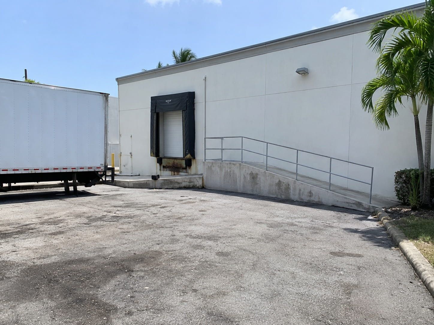 delivery truck backed up to a worn loading dock apron in Miami