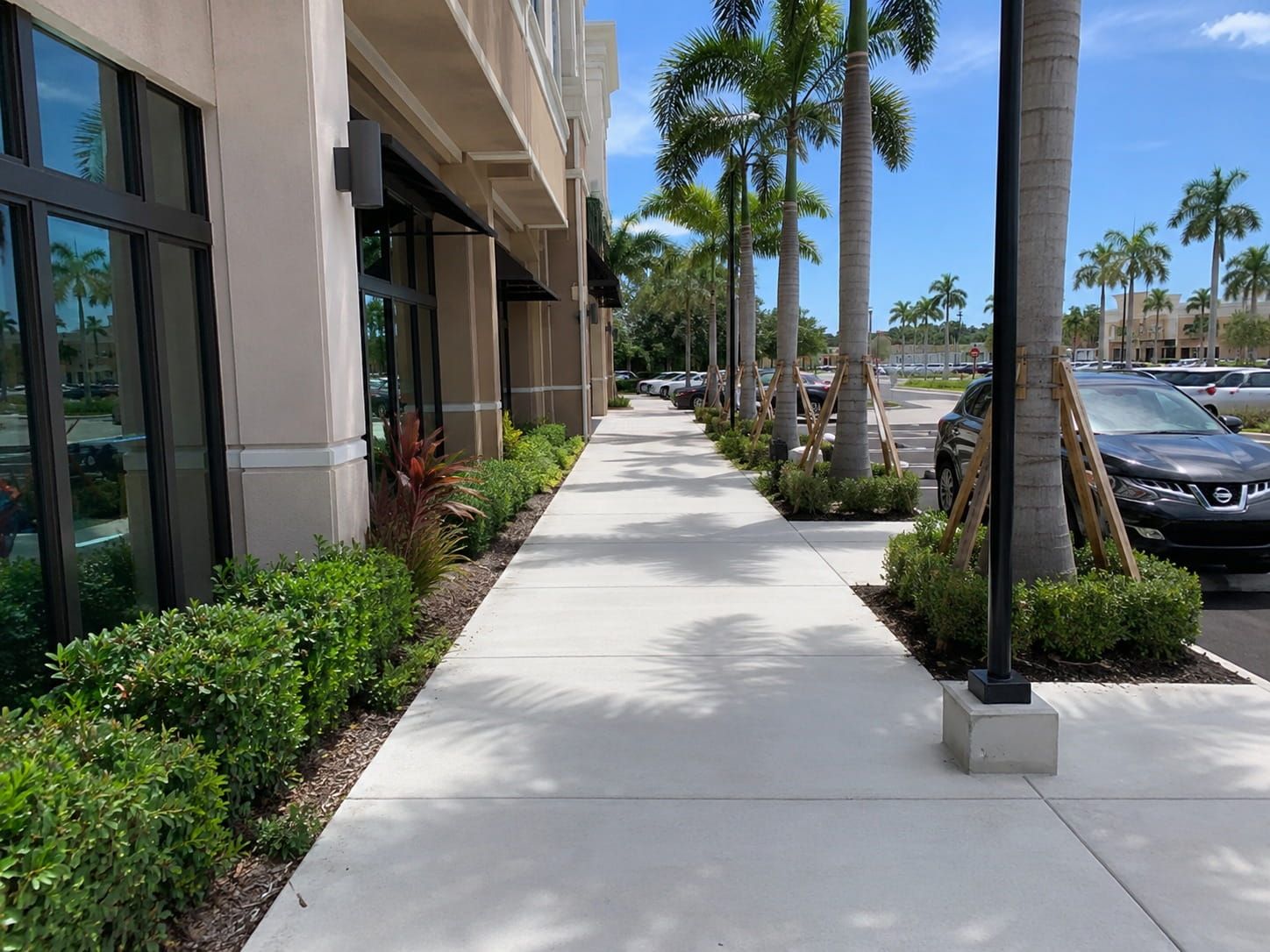 concrete sidewalk outside a Miami retail center parking lot